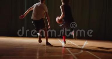 两名年轻的<strong>篮球</strong>运动员进行<strong>篮球比赛</strong>，业余选手进行大厅体育球拍运球